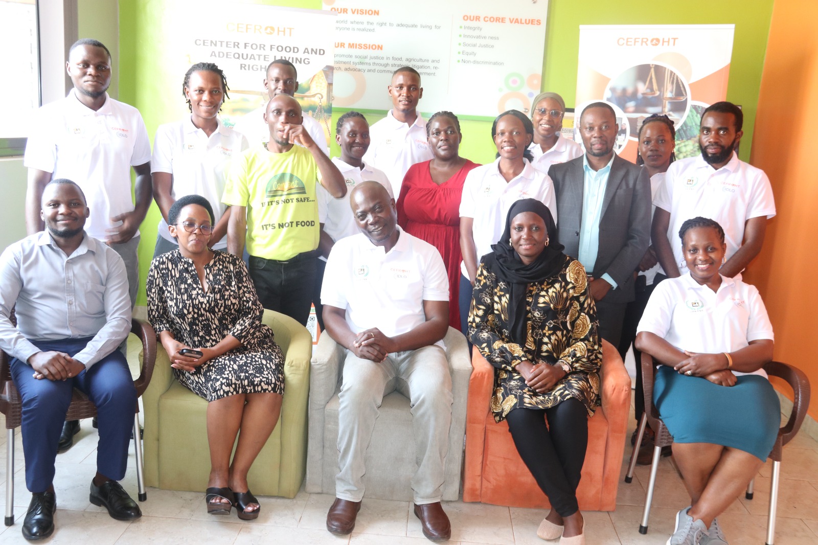 Members of a coalition partner organisation photographed together in their office, some wearing campaign t-shirts printed with 'It's not safe… it's not food'.
